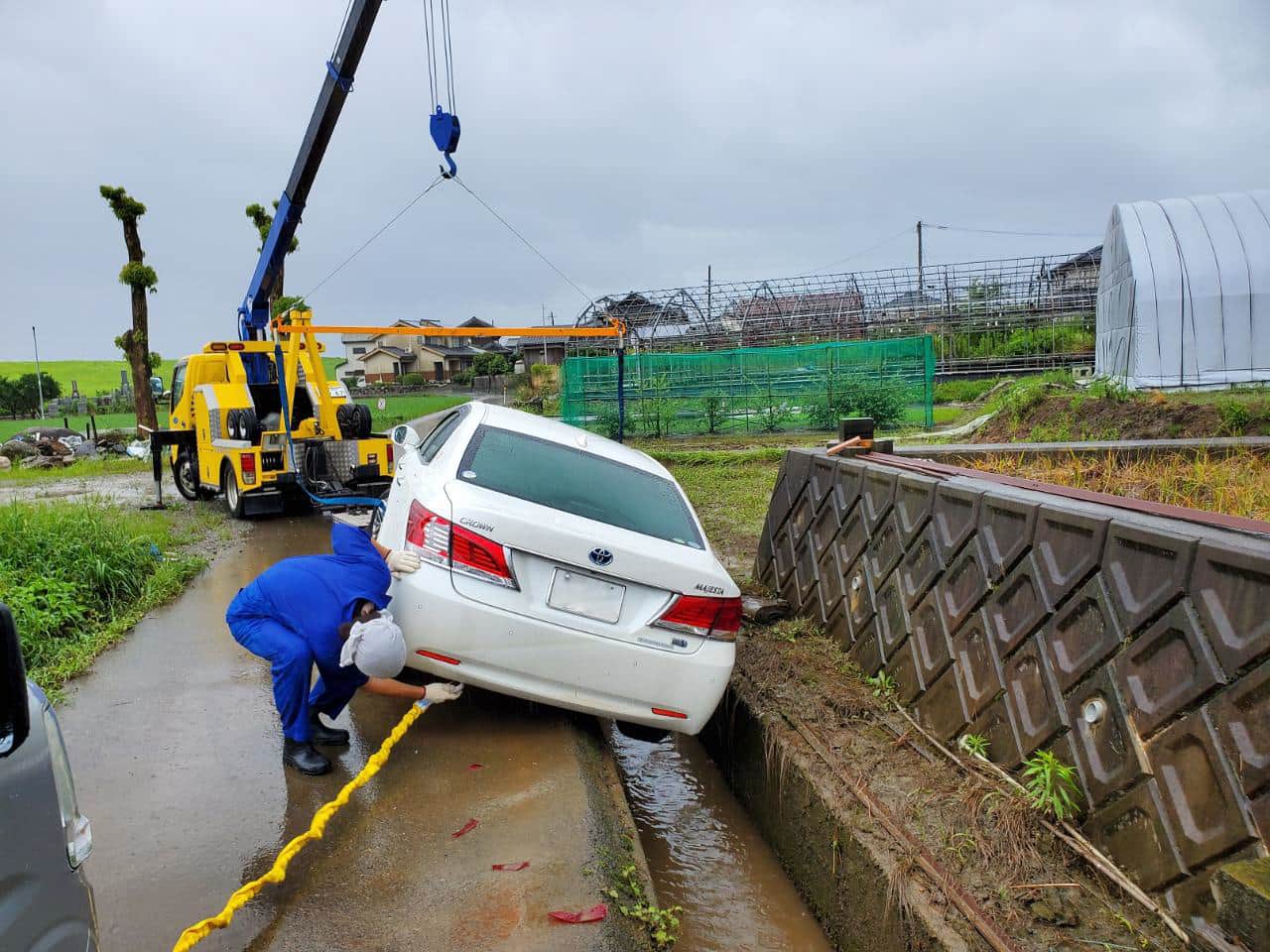 脱輪した車をクレーンで引き揚げている様子